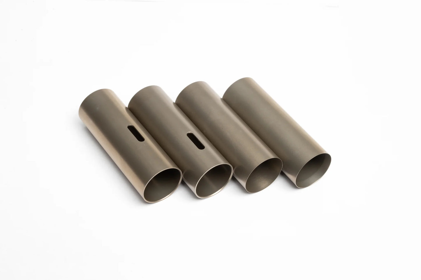 Four gold-tinted metal SPARK Accelerate Cylinder Kai variants by AIRSOFT97, showcasing the progressive porting slot configurations alongside full non-ported designs lined up on a white background.